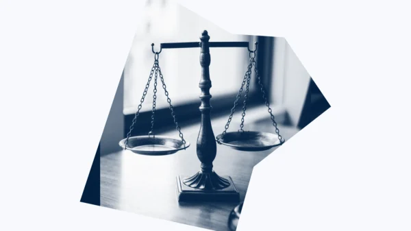 A dark blue and white graphic of scales of justice.