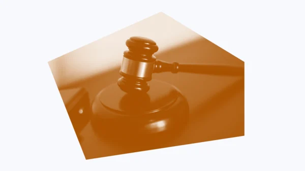 White and dark orange graphic of a gavel on a desk