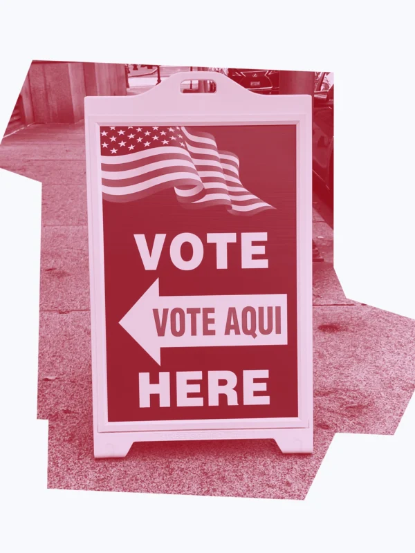 Dark red graphic of a "vote here/vote aqui" sign.