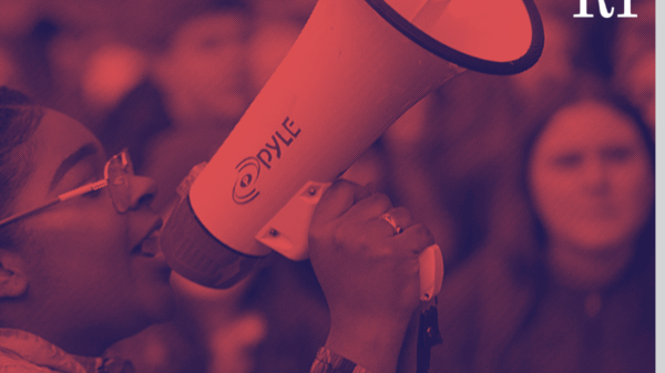 Red and blue photo of a student talking into a megaphone