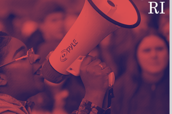 Red and blue photo of a student talking into a megaphone