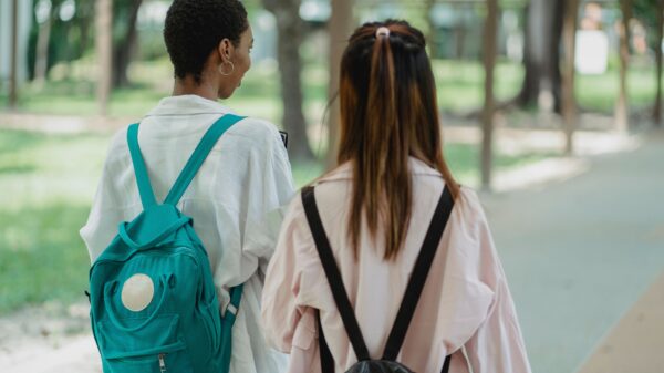 students with backpacks walking away from camera.