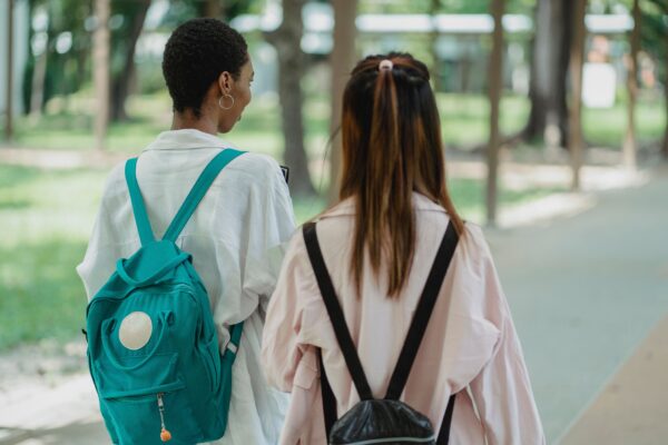 students with backpacks walking away from camera.