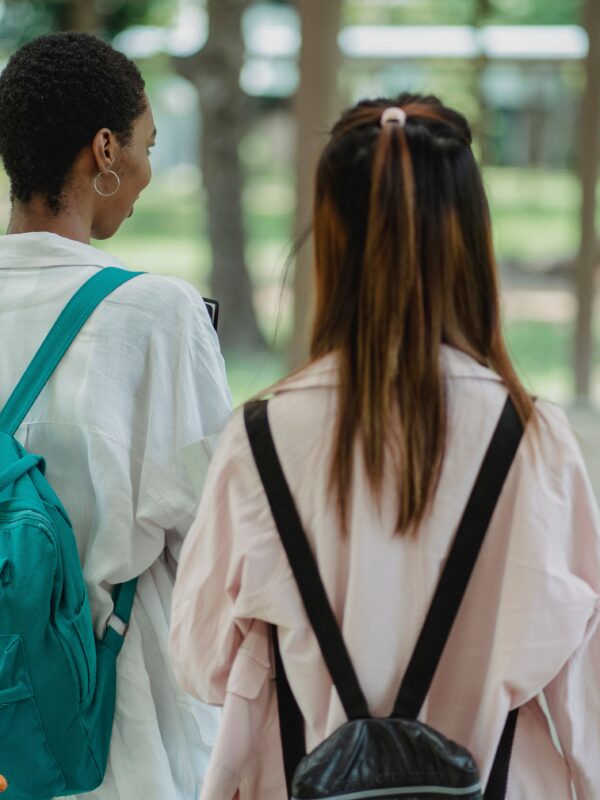students with backpacks walking away from camera.