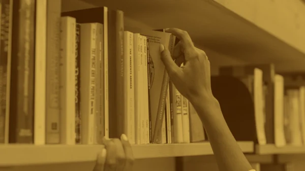 A person taking a book off of a bookshelf