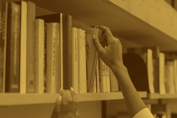A person taking a book off of a bookshelf